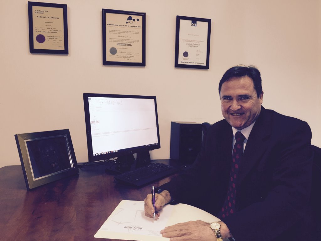 Daniel Towne sitting at his desk signing a page